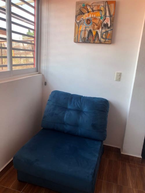 Silla tapizada azul en el departamento Zeus 12 de Alojamientos Zoogocho, San Andrés Huayapam, con arte moderno y ventana
