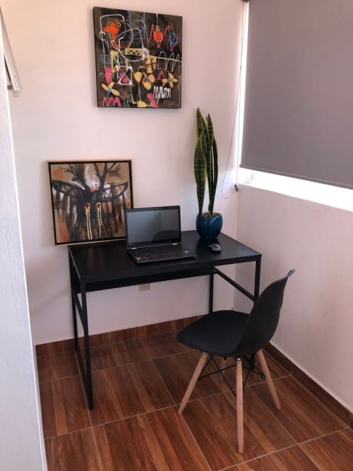 Espacio de trabajo moderno en Apartamento Zeus 12 de Alojamientos Zoogocho con escritorio negro, laptop, cuadro enmarcado y planta decorativa