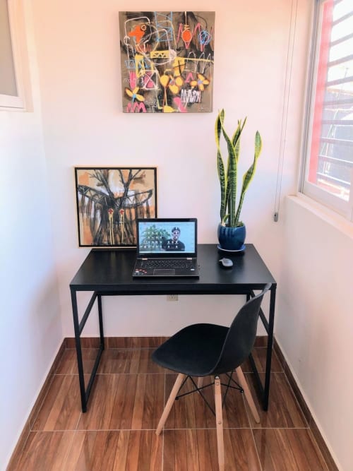 Espacio de trabajo moderno en el Apartamento Zeus 12 de Alojamientos Zoogocho con escritorio negro, laptop, planta y cuadro enmarcado