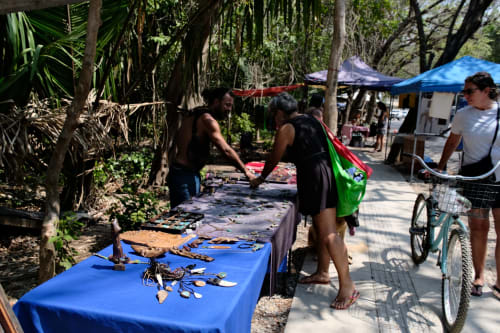 Outdoor market display at Villa Mango B&B in Nosara with local crafts and goods on blue tables under trees