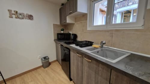 Cuisine moderne de l'appartement à Pont-Sainte-Maxence avec cuisinière, évier et décoration intérieure