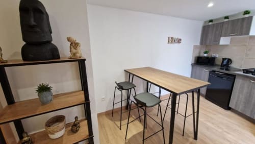 Cuisine et salle à manger modernes avec table en bois, tabourets de bar et mobilier contemporain