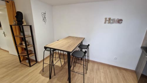 Kitchenette moderne avec table en bois, tabourets de bar et décoration murale 'Home' à Pont-Sainte-Maxence