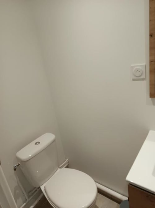 Salle de bain avec toilettes et lavabo blancs dans la villa de Location Saisonnière Pont-Sainte-Maxence, France