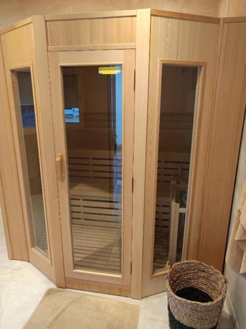 Cabine de sauna moderne en bois avec portes vitrées à la villa Pont-Sainte-Maxence, équipée de bancs en bois et panier en osier