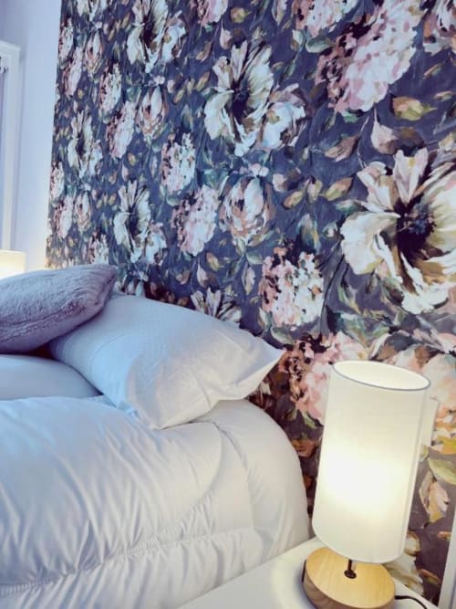 Acogedora habitación en AlmaMaterSalamanca con papel tapiz floral, ropa de cama blanca y lámpara de mesa de madera