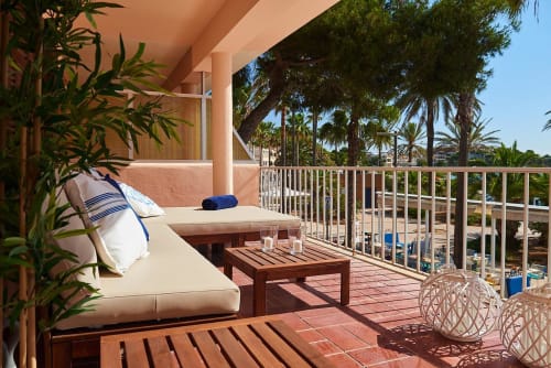 Beachfront terrace with lounge seating, palm trees, and sea views in Colonia de Sant Jordi