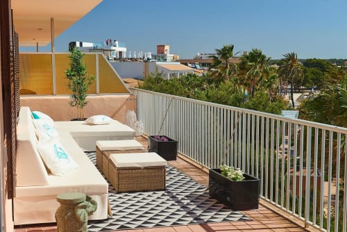 Coastal rooftop terrace in Colonia de Sant Jordi with lounge seating, palm trees, and sea views