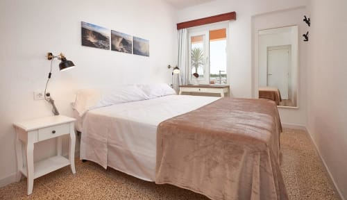 Bright hotel bedroom in Colonia de Sant Jordi with sea view, white bedding, wooden accents, and modern amenities