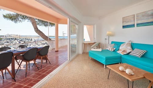 Bright coastal apartment in Colonia de Sant Jordi with turquoise sofa, terrace views of marina and sea, modern furnishings
