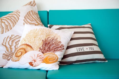 Turquoise couch with decorative coastal pillows featuring sea shells and 'Love You' text at Colonia de Sant Jordi hotel
