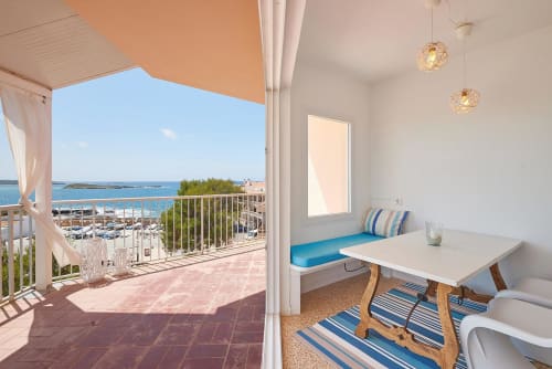 Beachfront hotel room with sea view balcony, dining nook, and coastal landscape in Colonia de Sant Jordi