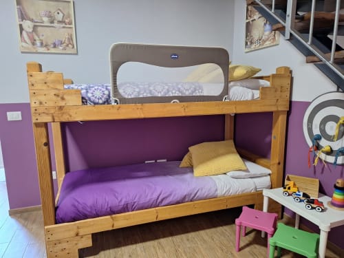 Wooden bunk bed with purple bedding in Locanda del Sasso family room, Crodo Italy