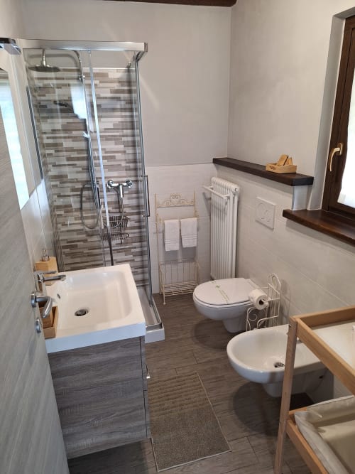 Bagno moderno presso Locanda del Sasso Rooms a Crodo con doccia, wc, bidet e accenti in legno