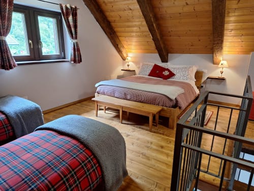 Accogliente appartamento di montagna alla Locanda del Sasso con travi in legno, biancheria a quadri e arredamento alpino a Crodo
