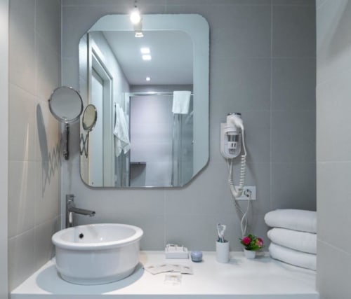 Modern bathroom in C'era una Volta Palermo B&B with round sink, illuminated mirror, towels, and hotel amenities