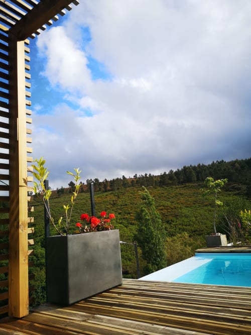 Terraço com vista para piscina e colinas florestadas no hotel de montanha Em Xisto em Góis, Portugal