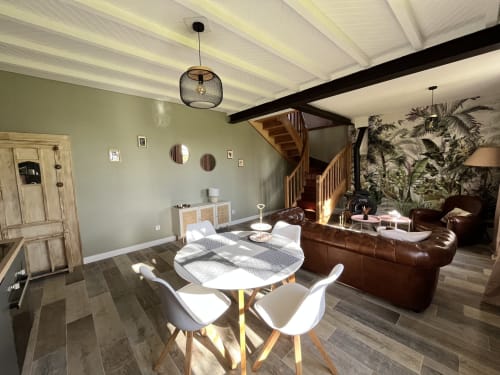 Intérieur de cottage moderne aux papillons de baccara à Gondrin avec salle à manger, canapé en cuir et escalier en bois