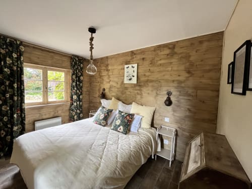 Chambre douillette aux murs en bois avec vue sur le jardin du gîte Les papillons de baccara à Gondrin, France