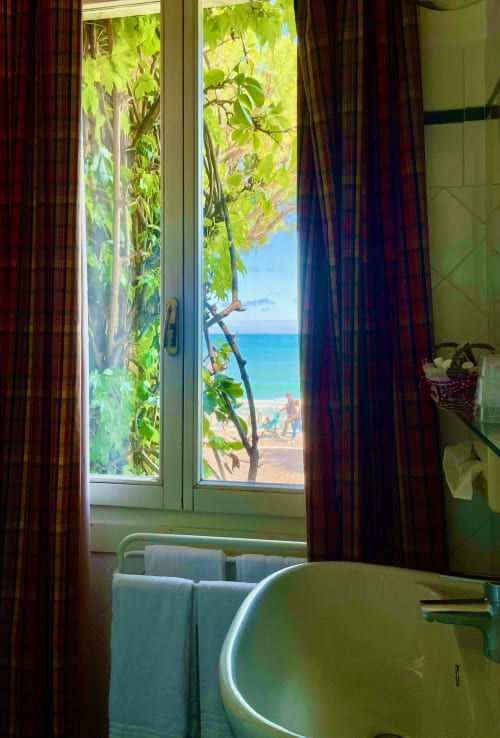 Meerblickzimmer des Hotel Beau Rivage in Alassio mit offenen Türen zum Strand und tropischer Begrünung