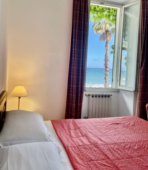 Chambre en bord de mer à l'Hôtel Beau Rivage Alassio avec vue sur la mer, palmier et équipements modernes