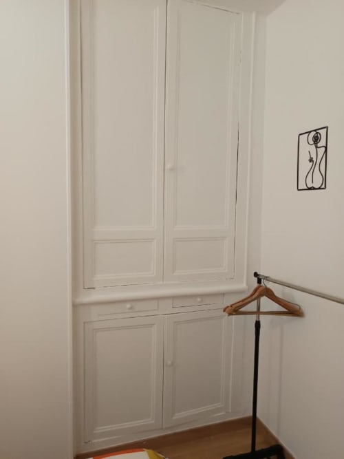 Placard minimaliste avec portes blanches à panneaux, cintre en bois et décoration murale à Pont-Sainte-Maxence