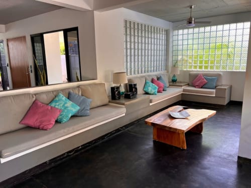 Moderna sala de estar con asientos beige, cojines coloridos, mesa de madera y vistas al océano en Casa Tsuki en Puerto