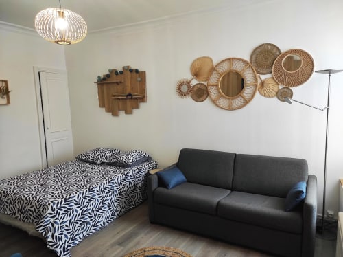 Chambre moderne à l'Accolade Châteaudun avec lit à motifs zèbre, canapé anthracite et art mural tressé