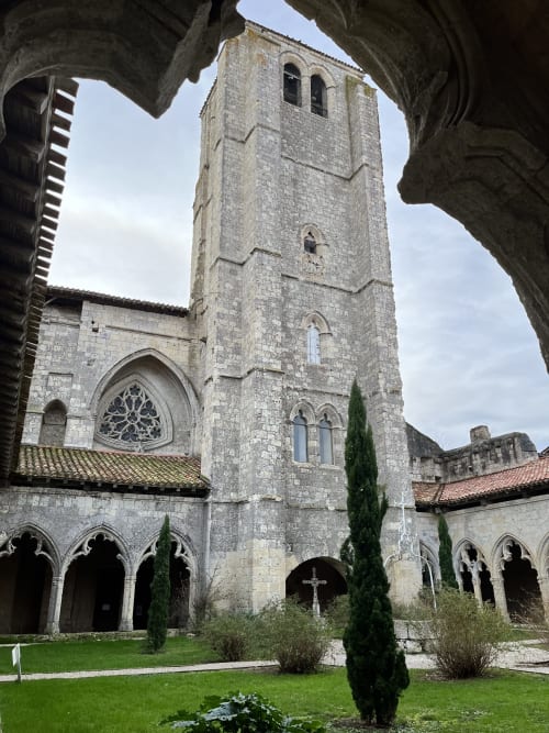 Tour clochère médiévale en pierre et cour de cloître de l'hôtel Les Papillons de Baccara à Gondrin, France
