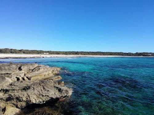 Aigües turqueses cristal·lines de la Mediterrània i costa rocosa a Colònia de Sant Jordi amb platja de sorra blanca i vegetació verda