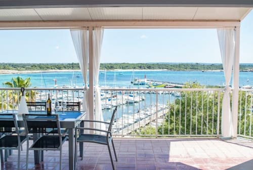 Terrassa d'apartament davant la mar amb vistes, taula de menjador i marina a Colònia de Sant Jordi