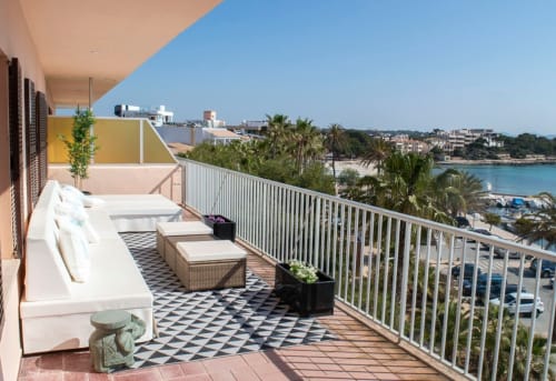 Ampla terrassa davant el mar amb gandules blanques, mobles de menjador i vistes panoràmiques de la platja de Colonia de Sant Jordi
