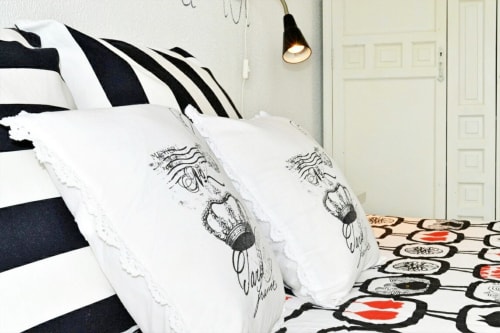 Dormitori elegant en WHITE Apartment amb roba de llit amb ratlles blanques i negres i coixins decoratius, Colonia de Sant Jordi