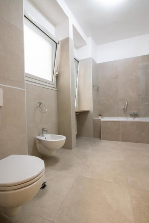 Moderno bagno dell'appartamento Dimore Verona a Verona con wc, bidet, lavabo e vasca, piastrelle di design neutro