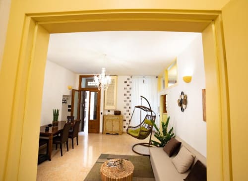 Ingresso con cornice giallo brillante di moderno appartamento a Verona con zona living, spazio pranzo e sedia sospesa presso Dimore Verona