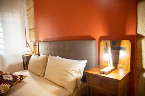 Camera moderna a Dimore Verona con testata imbottita grigia, cuscini crema, comodino in legno e illuminazione calda