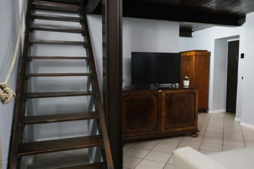 Moderno appartamento a Dimore Verona con scala in legno, mobile TV e pavimentazione in piastrelle