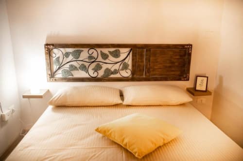 Camera da letto moderna presso l'appartamento Dimore Verona a Verona con testata in legno e cuscini decorativi