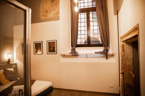 Camera elegante a Dimore Verona con opere d'epoca, alte finestre con tende beige e arredamento veneziano classico