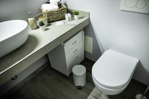 Bagno moderno nell'appartamento Dimore Verona con vasca indipendente bianca, WC, lavabo a bacile e vanity organizzato