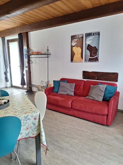 Rotes Sofa mit bunten Kissen in hellem Wohnzimmer der Locanda del Sasso Rooms B&B, Crodo Italien