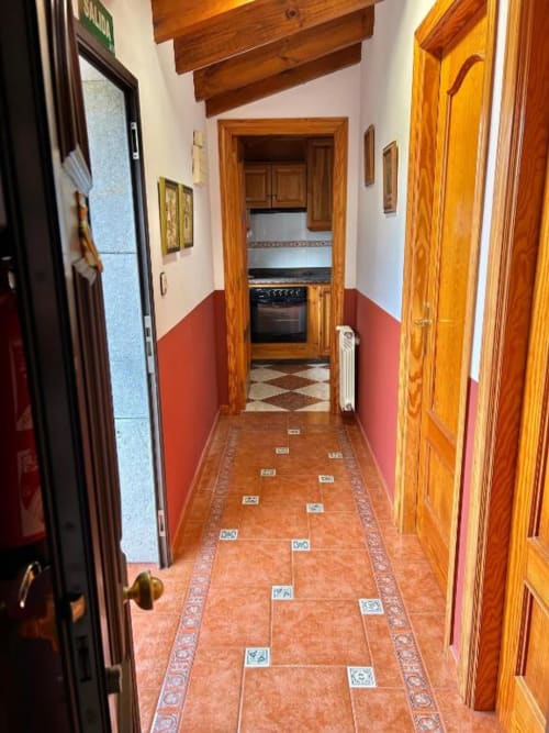 Pasillo del apartamento Las Llaviadas en Ortiguero de Cabrales con baldosas de terracota y puertas de madera