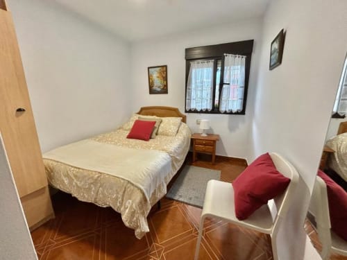 Acogedora habitación en el apartamento Las Llaviadas de Ortiguero de Cabrales con camas gemelas, vistas a la montaña y suelos de madera