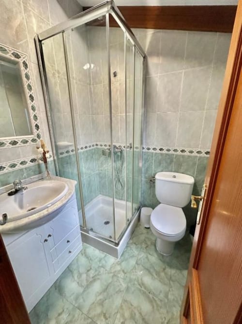 Baño moderno del apartamento Las Llaviadas en Ortiguero de Cabrales con ducha, lavabo blanco y inodoro