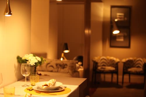 Mesa de jantar elegante no New Oporto Apartments no Porto com flores brancas, mise en place e iluminação ambiente aconchegante