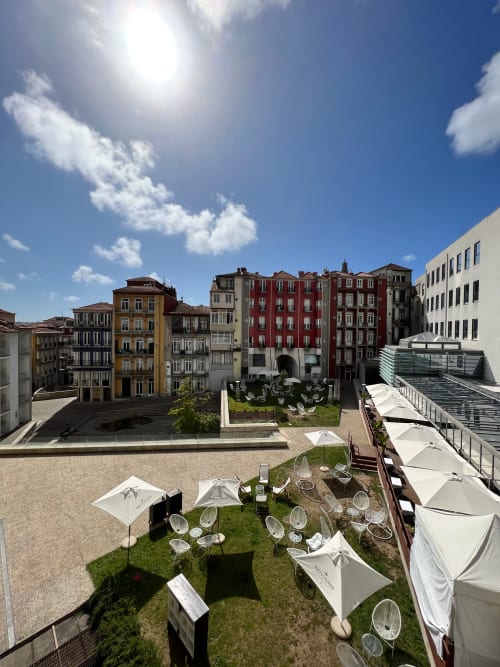 Terraço na cobertura do New Oporto Apartments com guarda-sóis com vista para a arquitetura histórica do Porto