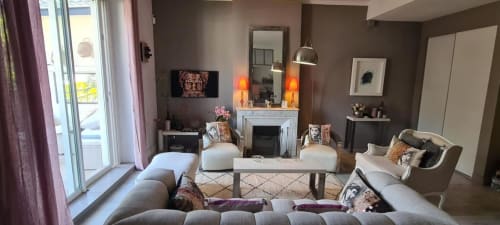 Le salon luxueux du Cocon de Chris à Marseille : sièges gris, cheminée, luminaires suspendus et vue sur balcon