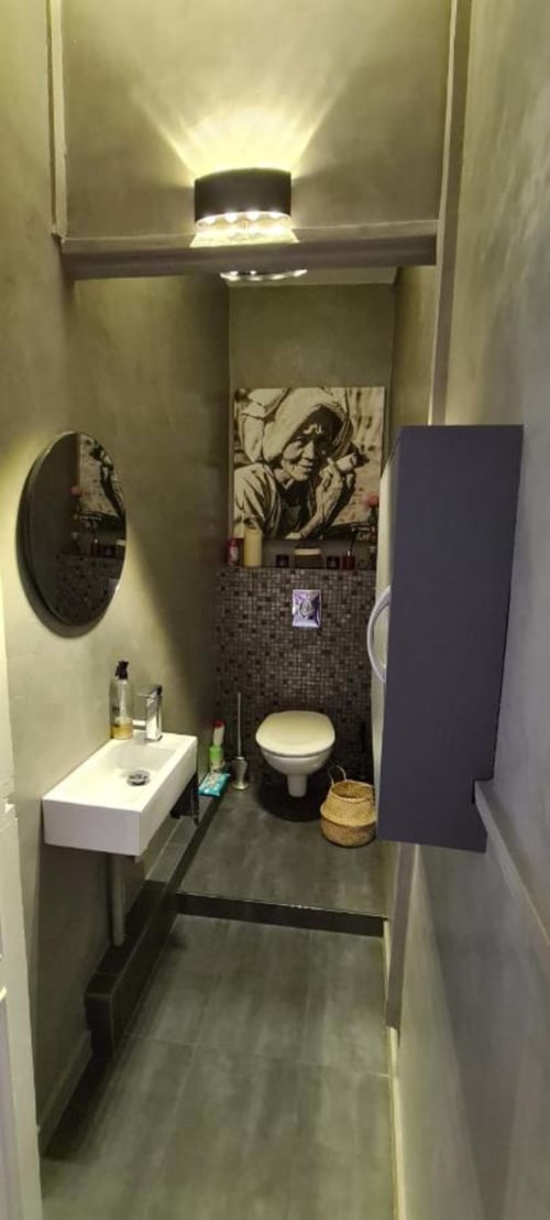 Salle de bain moderne du Cocon de Chris Marseille avec lavabo blanc, toilettes et décoration murale artistique