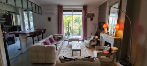 Le Cocon de Chris Marseille : salon moderne avec canapé crème, cheminée, bureau et vue sur les arbres depuis le balcon