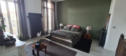 Chambre moderne au Cocon de Chris à Marseille avec mur d'accent vert, lit queen-size et vue sur la ville